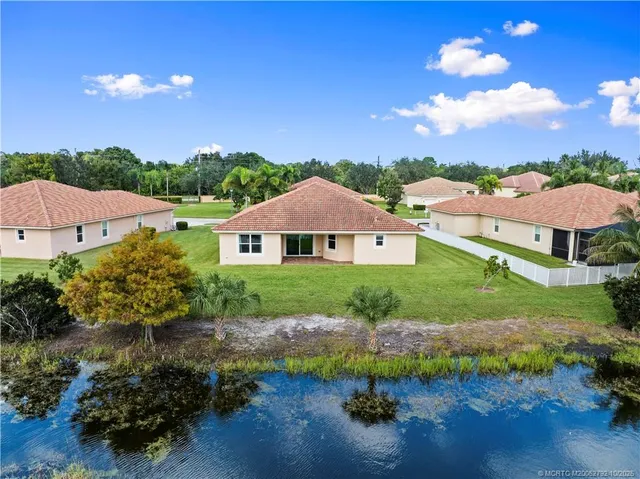 an aerial view of a house with outdoor space and a lake view