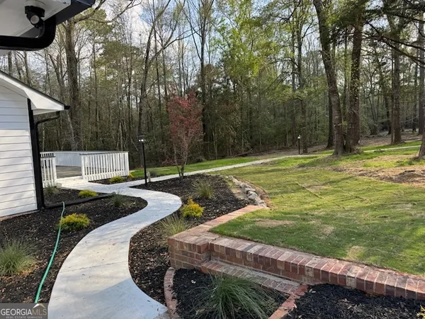 a view of a backyard with table and chairs and wooden fence