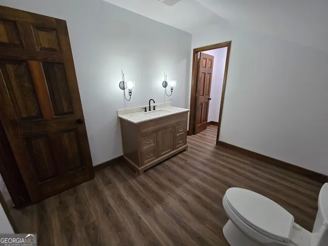 a view of bathroom with a toilet and a wooden floor