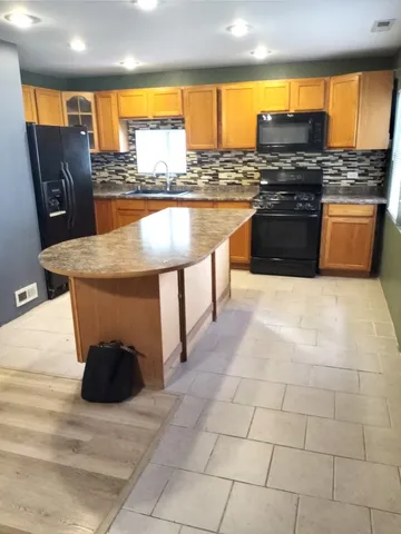 a kitchen with stainless steel appliances granite countertop a stove and a refrigerator