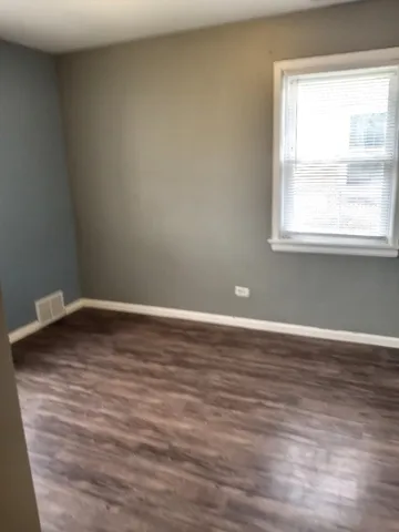 a view of a room with wooden floor and a window