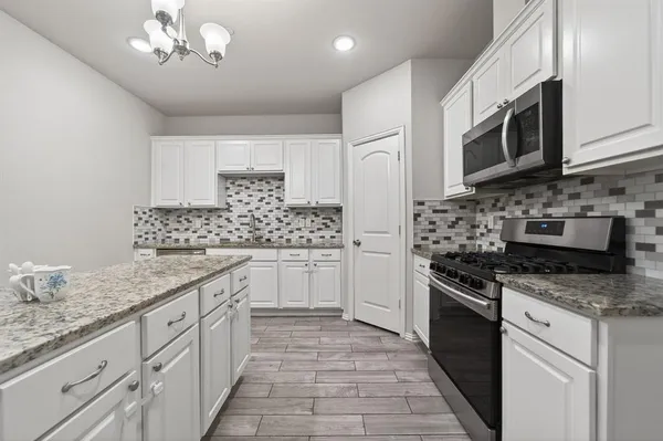 a kitchen with stainless steel appliances granite countertop a sink and stove top oven