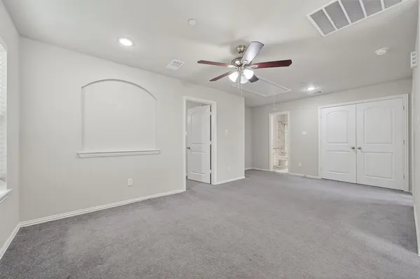 an empty room with fan and windows