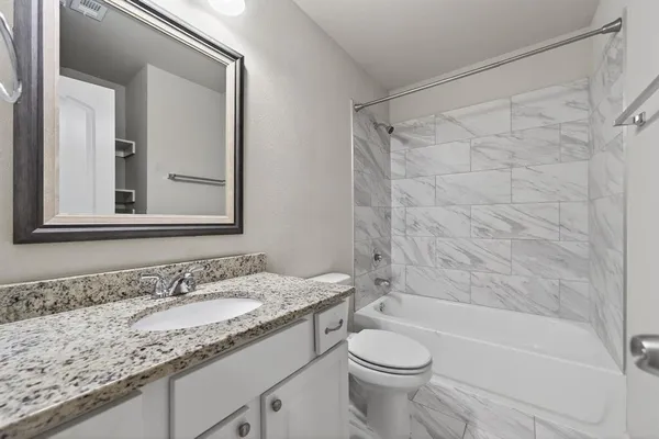a bathroom with a granite countertop sink toilet and shower