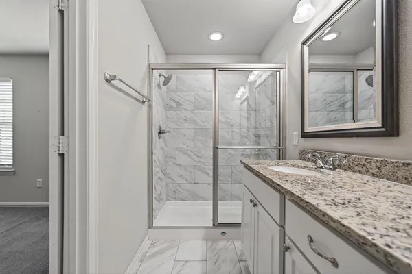 a bathroom with a granite countertop sink and mirror