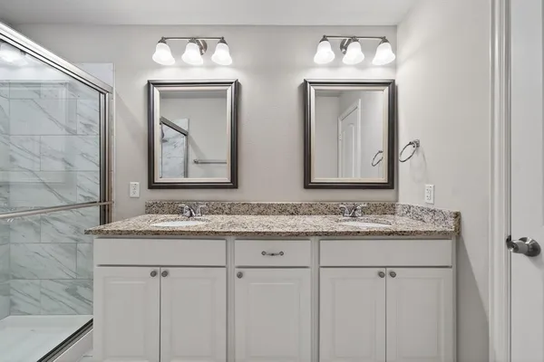 a bathroom with double sink and a mirror