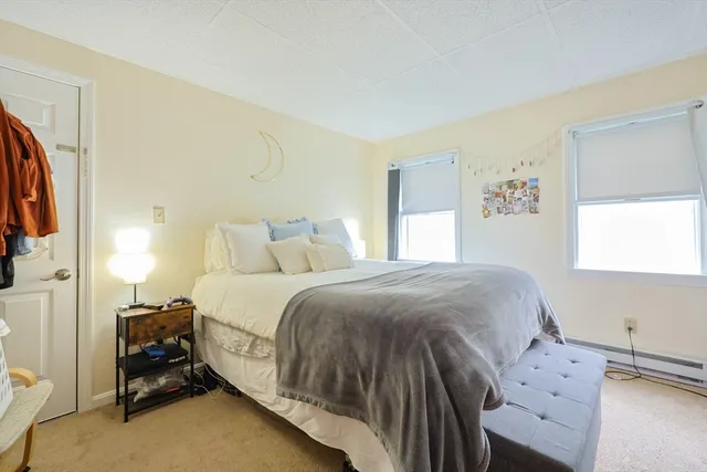 a bed sitting in a bedroom next to a window