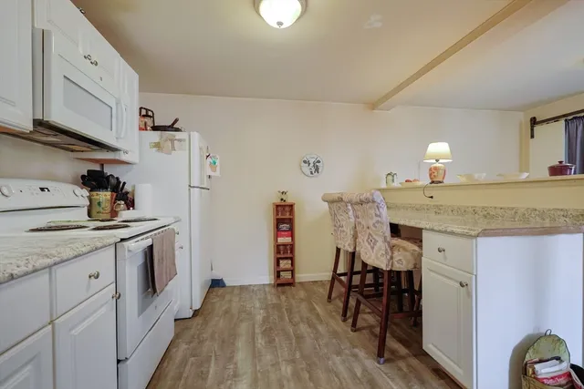a kitchen with a sink cabinets and wooden floor