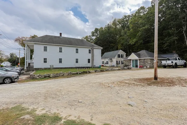a white house that has a tree in front of it