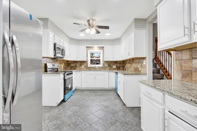 a kitchen with white cabinets and white appliances