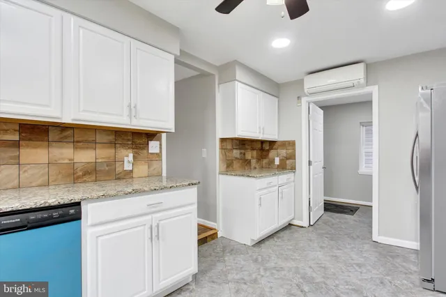 a kitchen with white cabinets and refrigerator