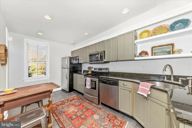 a kitchen with stainless steel appliances granite countertop a sink and a stove