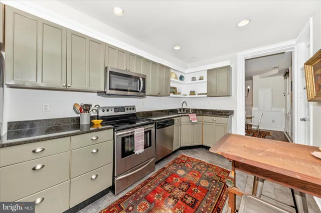 a kitchen with stainless steel appliances granite countertop a sink and cabinets