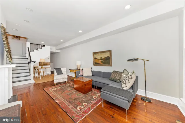 a living room with furniture and a wooden floor