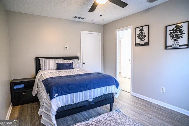 a bedroom with a bed and wooden floor