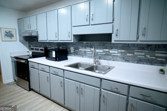 a kitchen with white cabinets and a sink