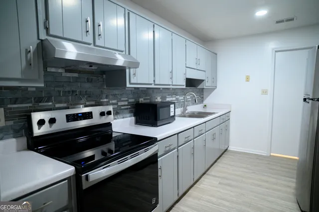 a kitchen with stainless steel appliances granite countertop a stove and a cabinets