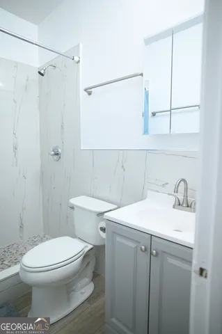 a bathroom with a sink a toilet and shower