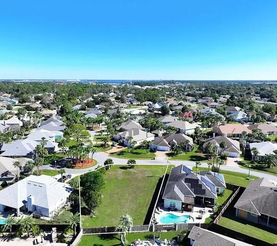 an aerial view of a city with lots of residential buildings ocean and mountain view in back