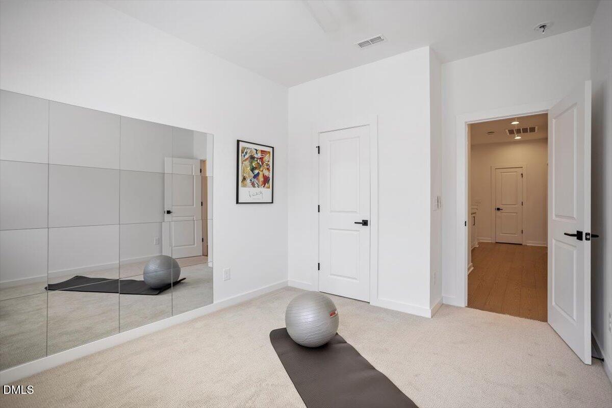 6419 Tanner Oak Lane Raleigh, NC 27613 - Photo 30 of 39 a bedroom with a bed and gym equipment