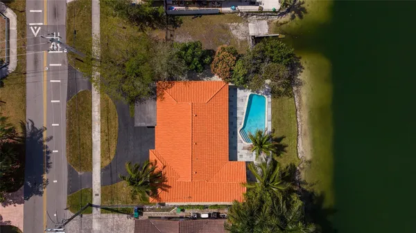 a view of an empty room with wooden floor and windows