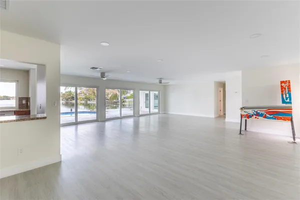a view of a livingroom with wooden floor and kitchen space