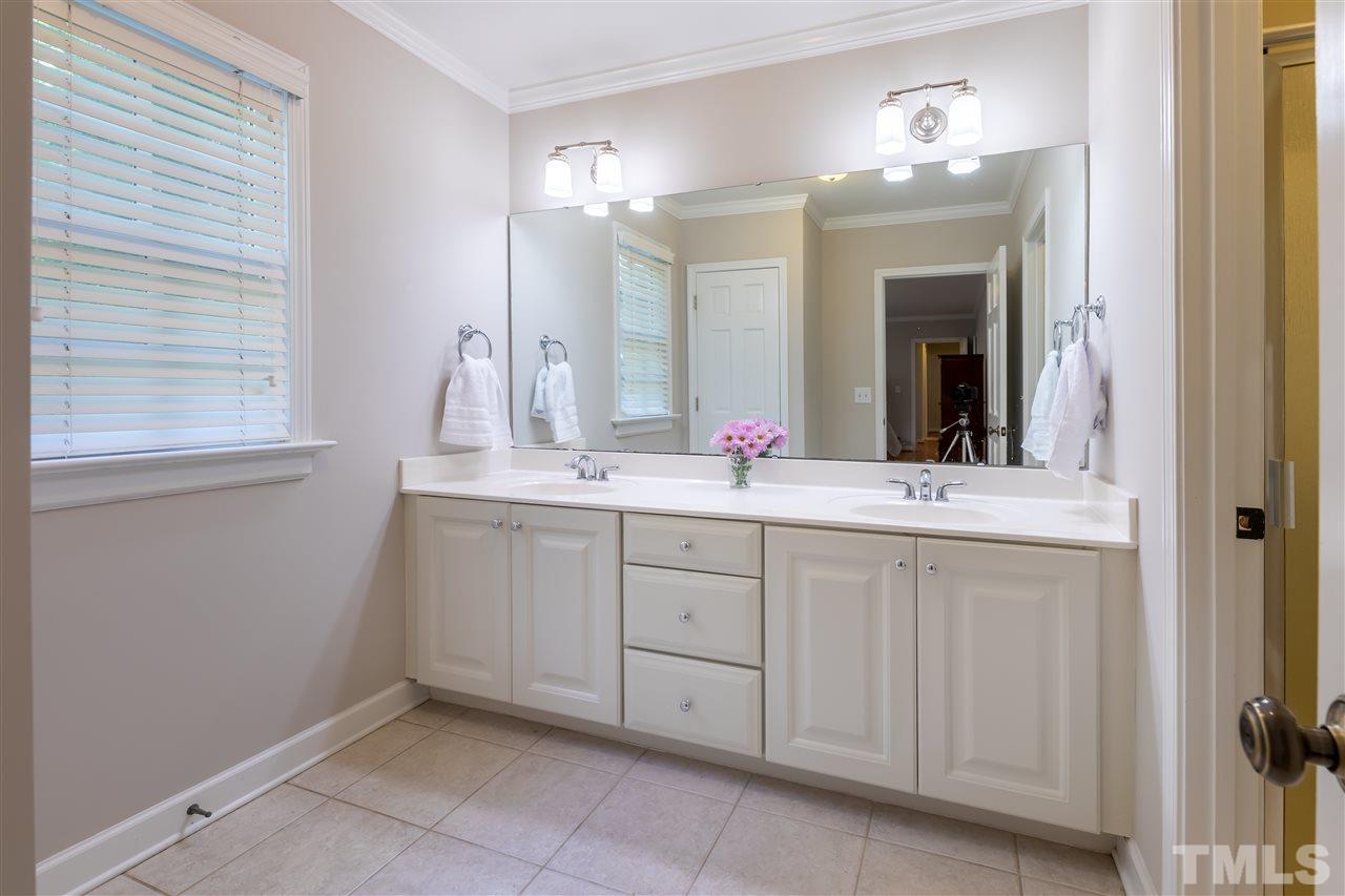 914 Canterbury Road Raleigh, NC 27607 - Photo 14 of 29 a bathroom with a double vanity sink and a mirror