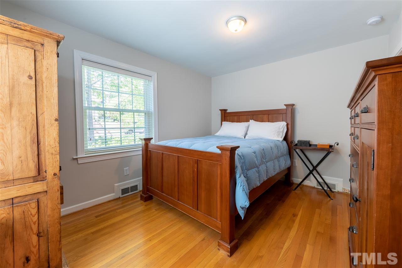 914 Canterbury Road Raleigh, NC 27607 - Photo 17 of 29 a bedroom with a bed and wooden floor
