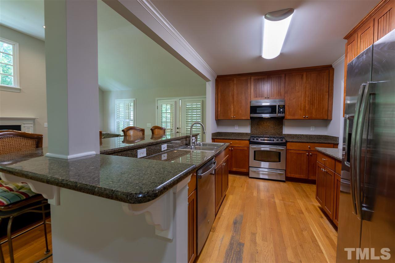 914 Canterbury Road Raleigh, NC 27607 - Photo 6 of 29 a kitchen with kitchen island granite countertop a sink stove and refrigerator