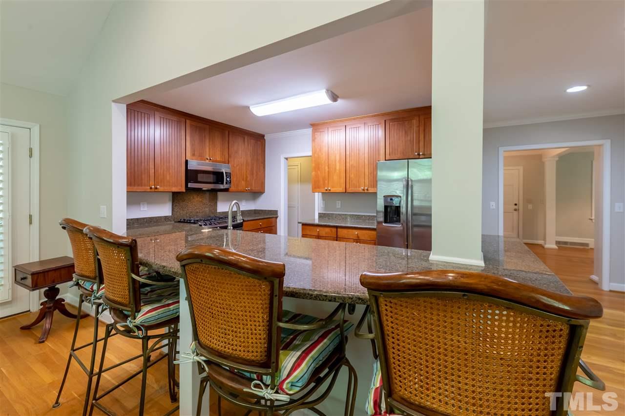 914 Canterbury Road Raleigh, NC 27607 - Photo 7 of 29 a kitchen with a sink a counter and chairs
