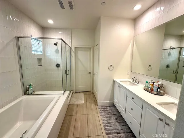 a spacious bathroom with a double vanity sink and mirror