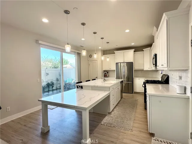 a large kitchen with kitchen island a sink a center island stainless steel appliances and a center island