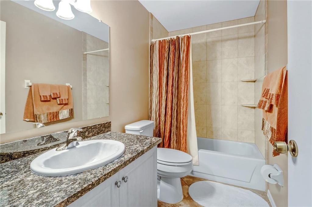 5675 Whitaker Road, Unit B202 Naples, FL 34112 - Photo 20 of 26 a bathroom with a granite countertop sink toilet and shower