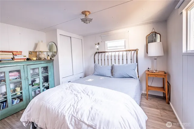 a bedroom with a bed and dresser with mirror