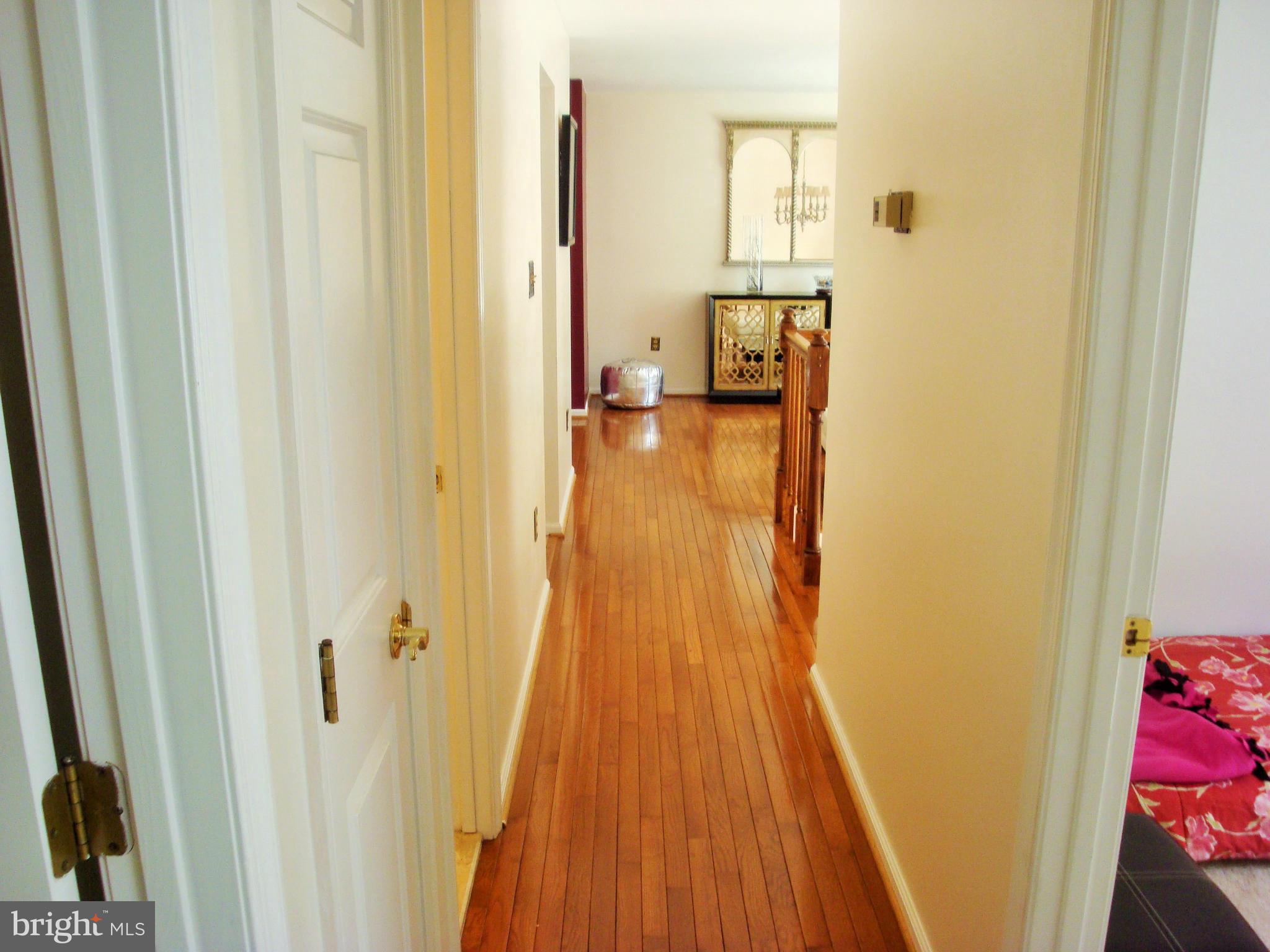 10159 Marshall Pond Road Burke, VA 22015 - Photo 19 of 28 a view of a hallway with wooden floor and a bathroom