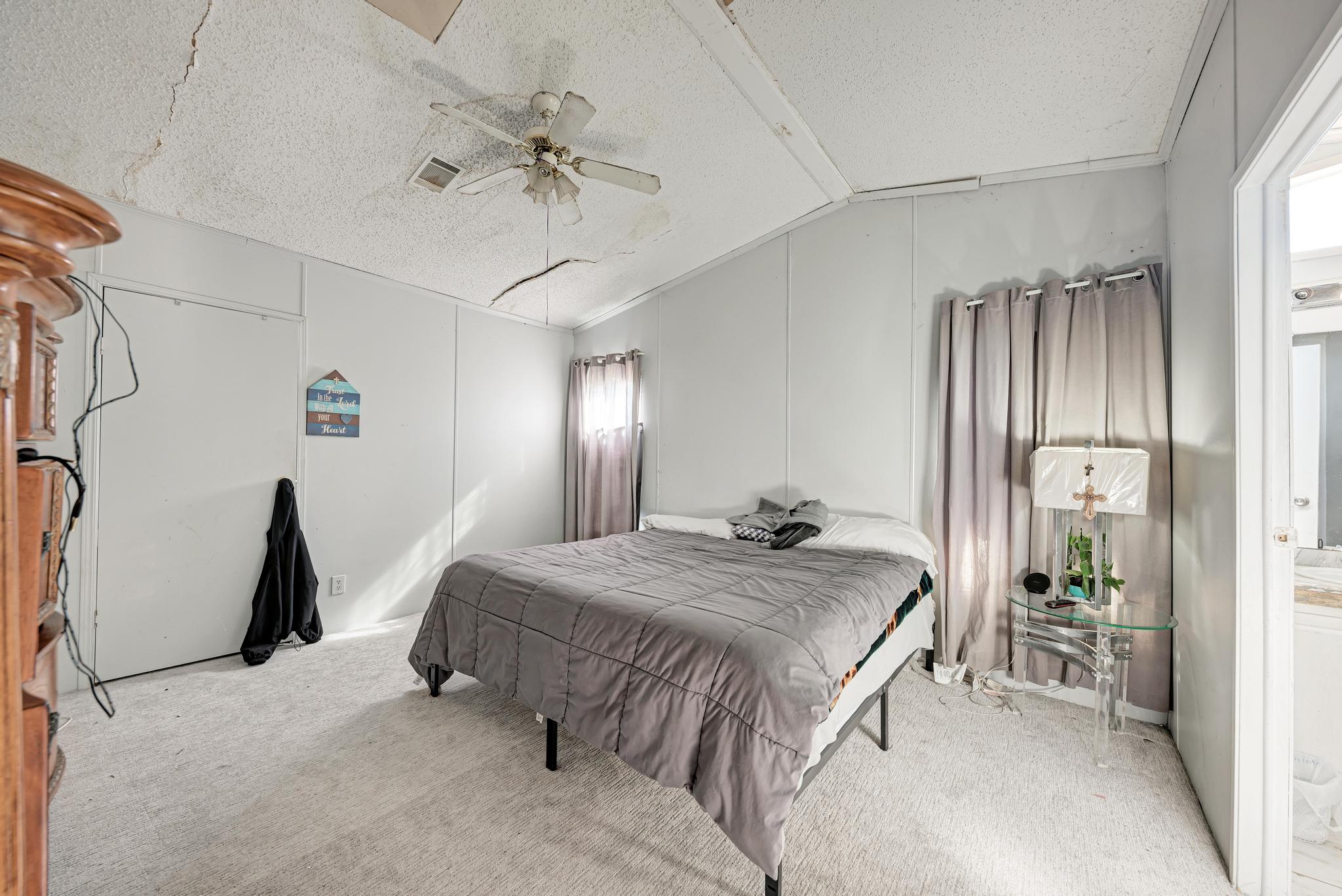 20113 Maynard Court Coupland, TX 78615 - Photo 15 of 37 a spacious bedroom with a bed and a chandelier