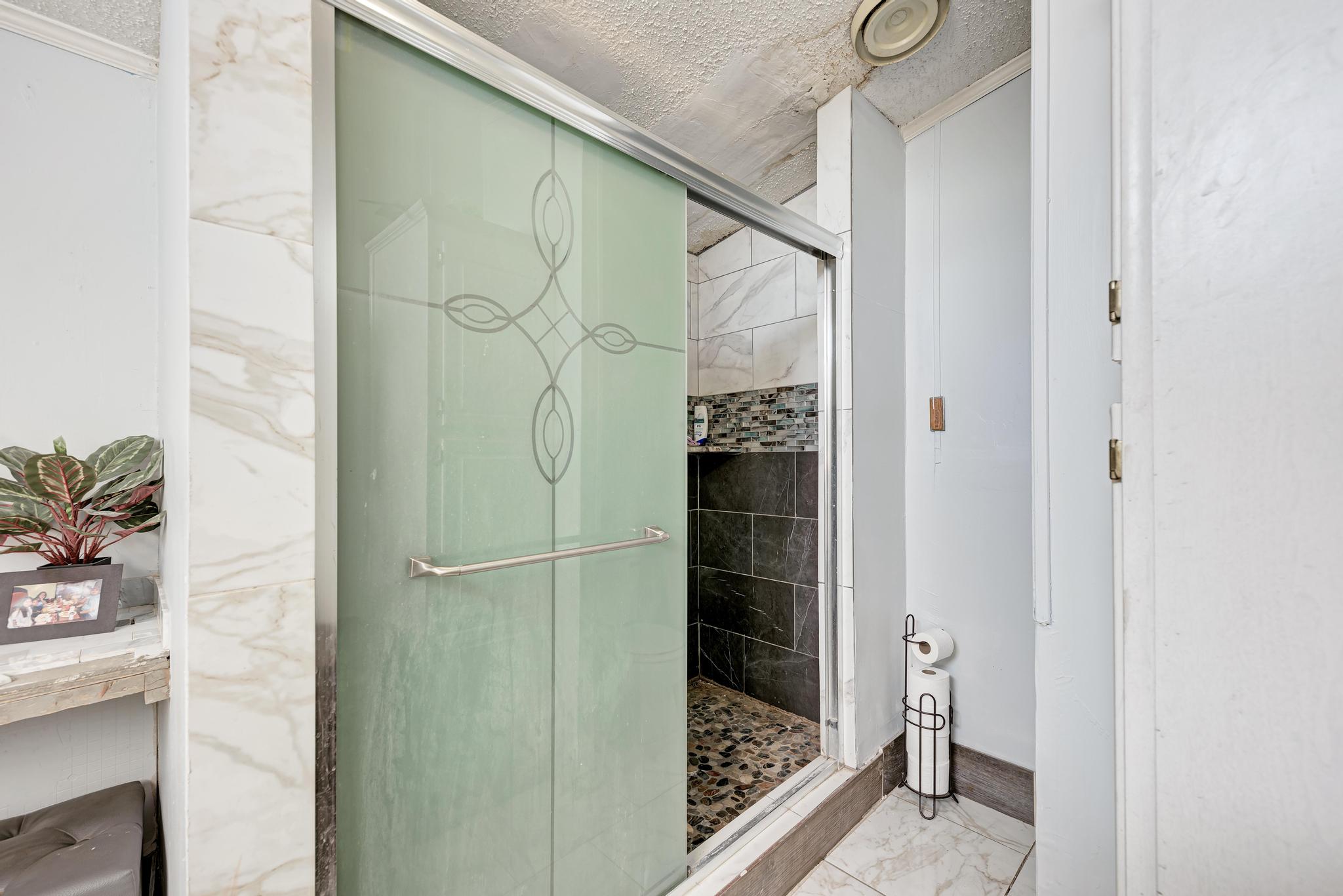 20113 Maynard Court Coupland, TX 78615 - Photo 18 of 37 a bathroom with a glass shower door