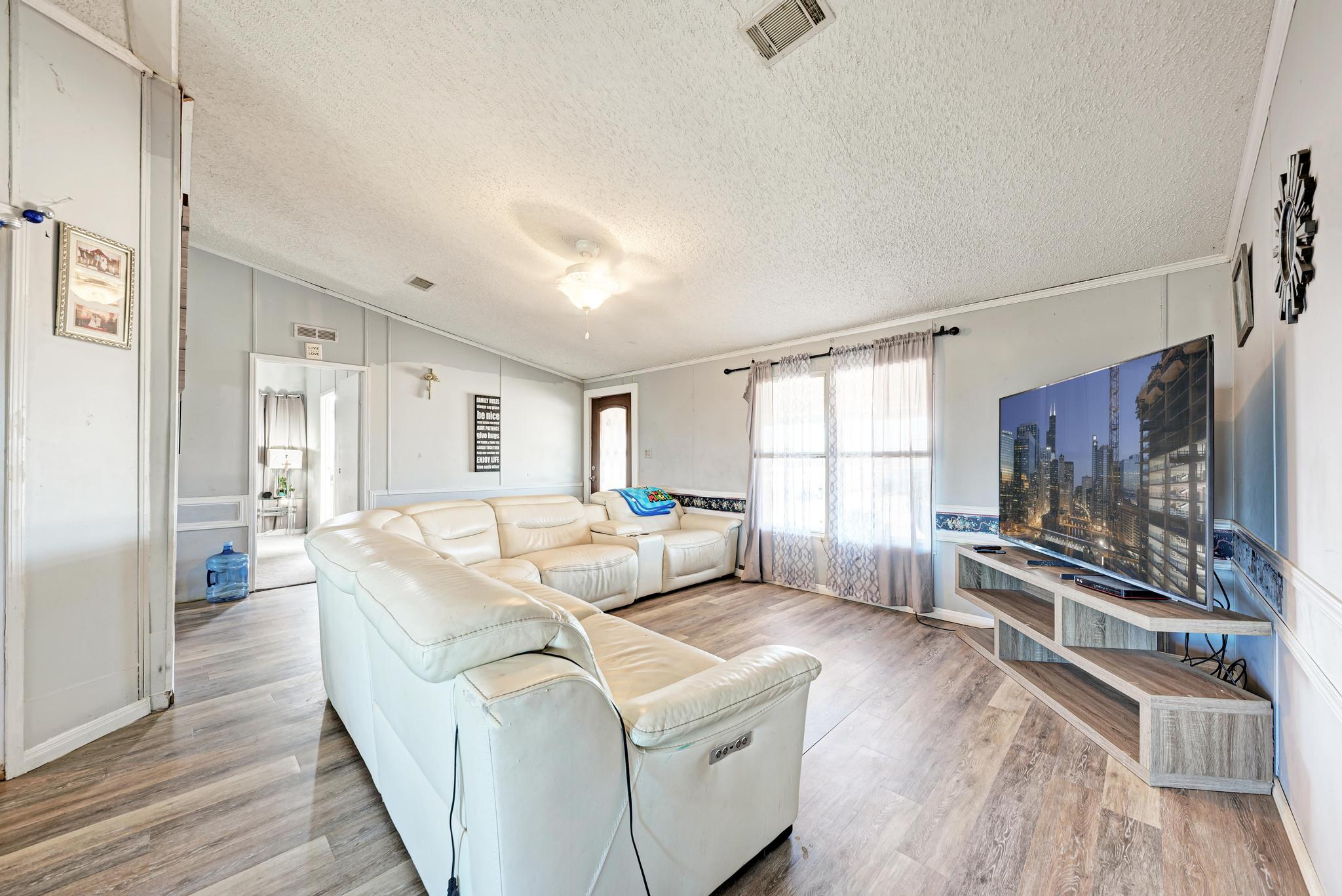 20113 Maynard Court Coupland, TX 78615 - Photo 9 of 37 a living room with furniture a flat screen tv and a fireplace