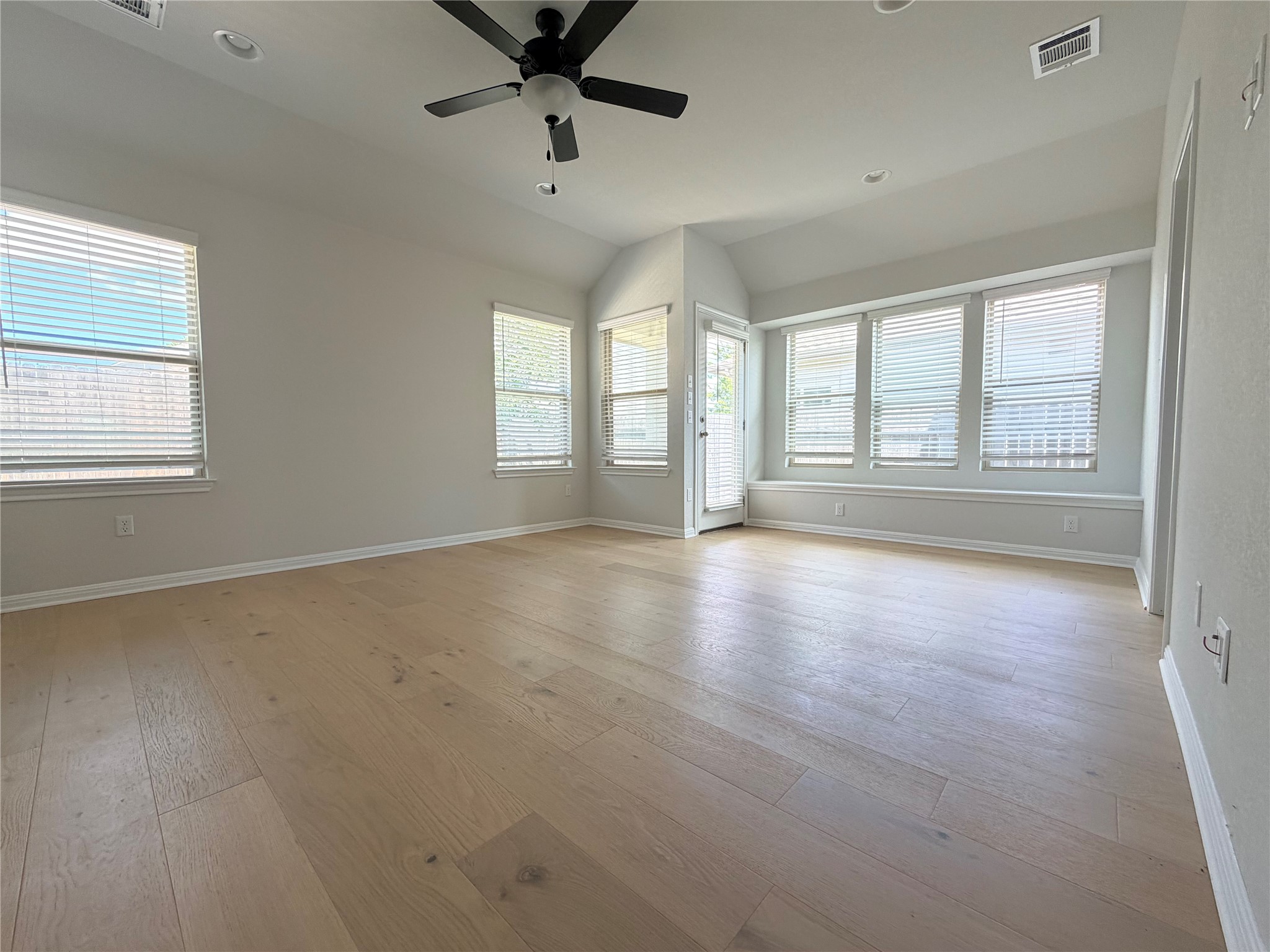 2813 Hopi Path, Unit 11 Leander, TX 78641 - Photo 7 of 17 Empty room with a ceiling fan, light wood-style floors, vaulted ceiling, and recessed lighting