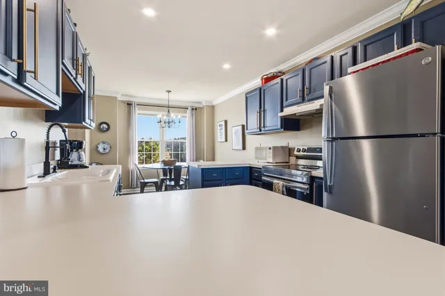 a kitchen with stainless steel appliances a refrigerator and a table