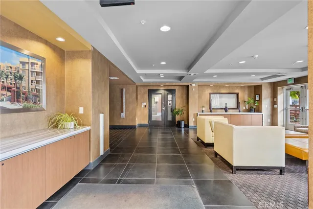 a large hall with stainless steel appliances kitchen island granite countertop a large window and couch