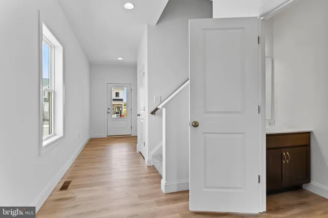 a view of a hallway with wooden floor and staircase