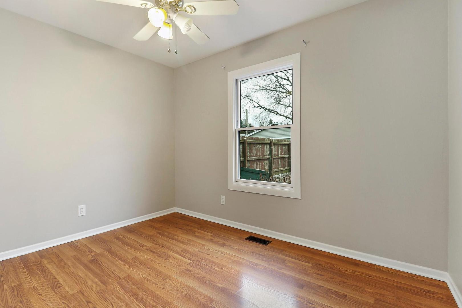 419 Foster Road Wauconda, IL 60084 - Photo 9 of 21 an empty room with wooden floor chandelier and windows