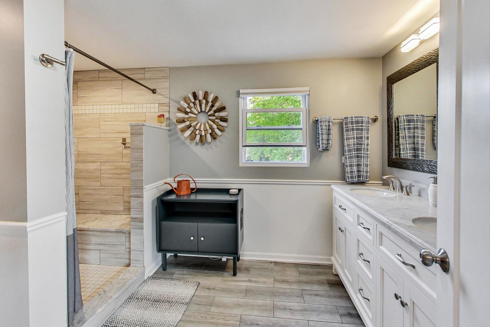 138 Northgate Road Riverside, IL 60546 - Photo 13 of 30 a bathroom with a double vanity sink a two mirror a window and a shower