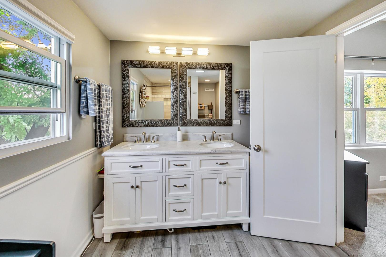 138 Northgate Road Riverside, IL 60546 - Photo 14 of 30 a bathroom with a double vanity sink a mirror and next to a window