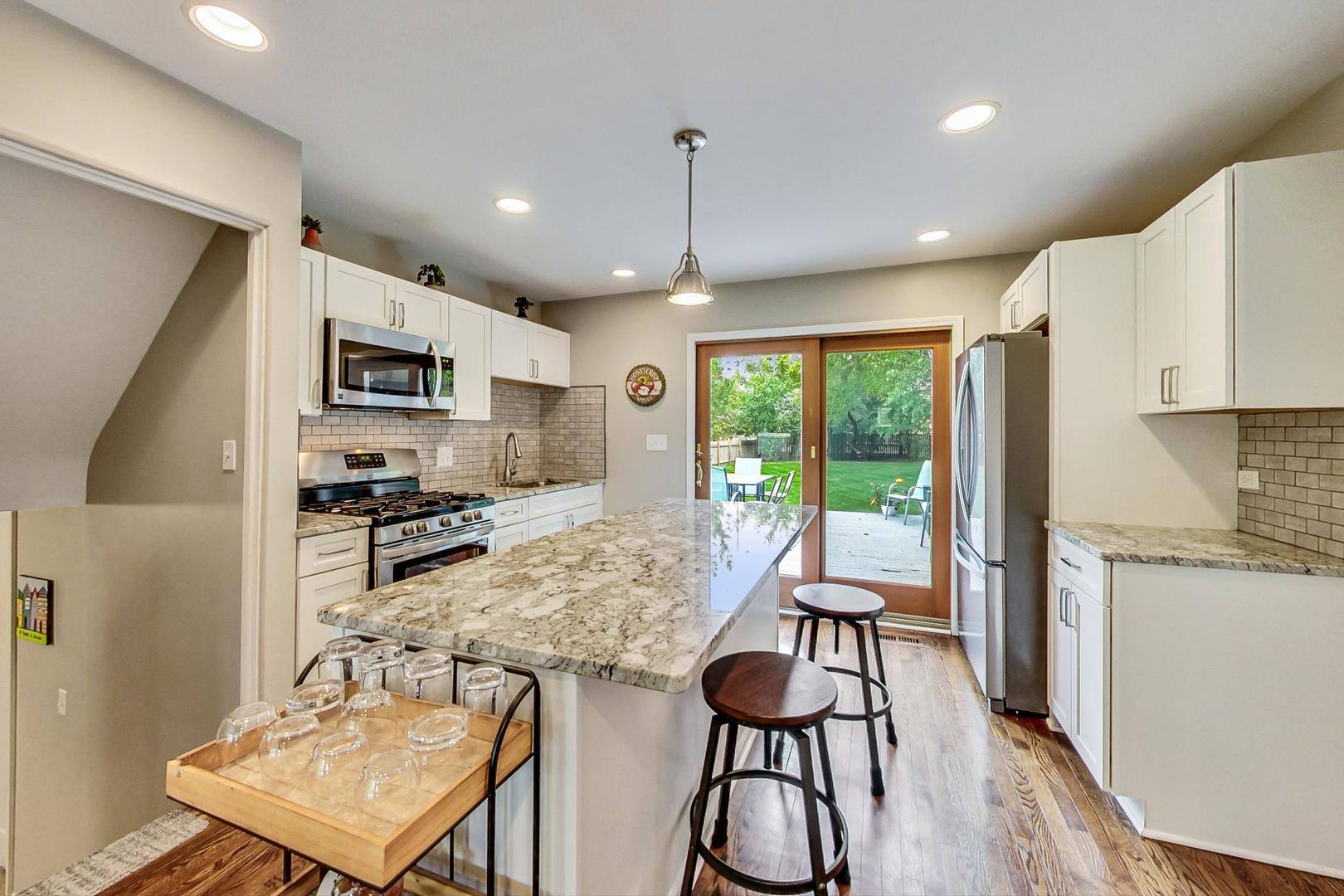 138 Northgate Road Riverside, IL 60546 - Photo 4 of 30 a kitchen with sink refrigerator dining table and chairs