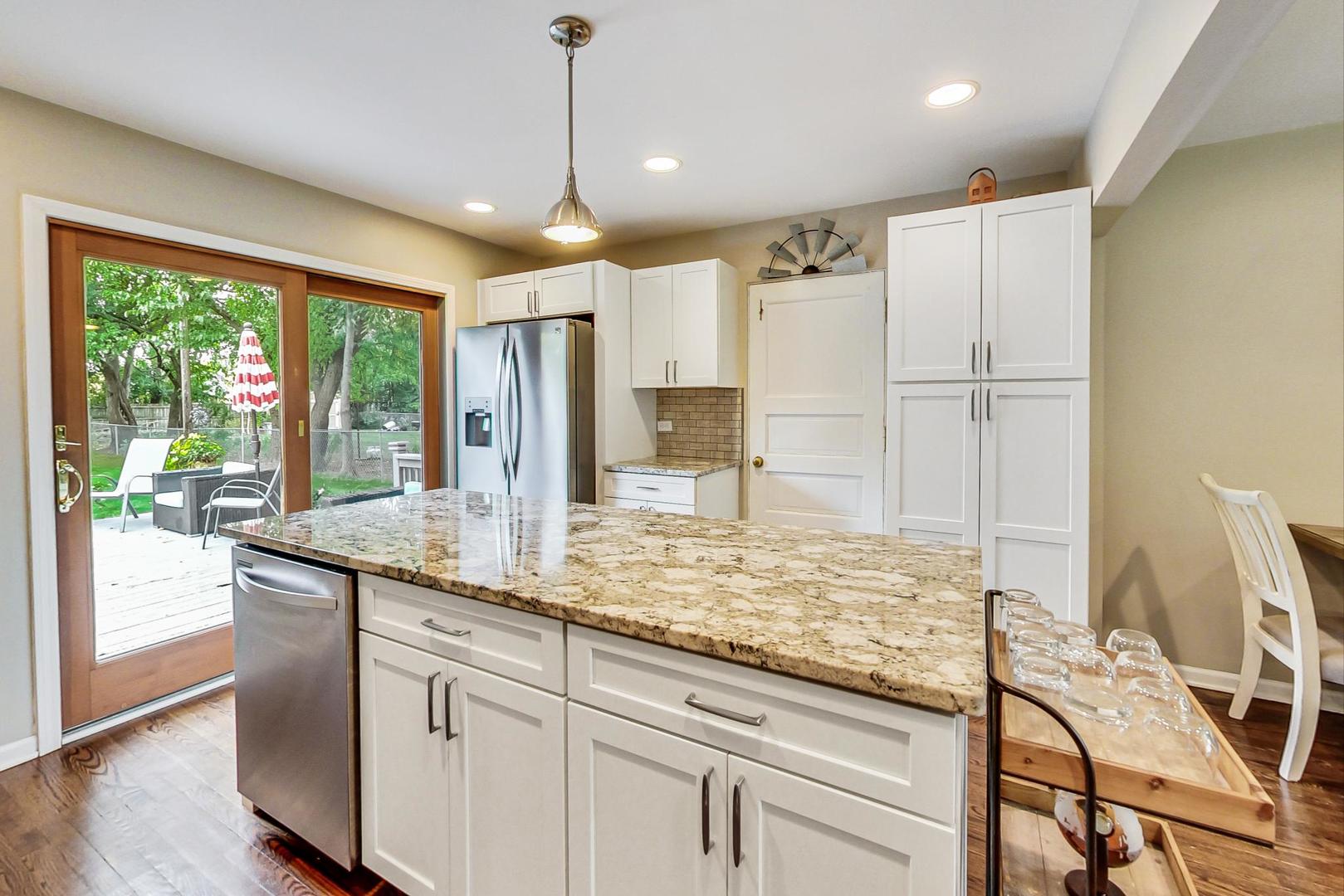 138 Northgate Road Riverside, IL 60546 - Photo 5 of 30 a kitchen with kitchen island granite countertop a stove and a wooden floors