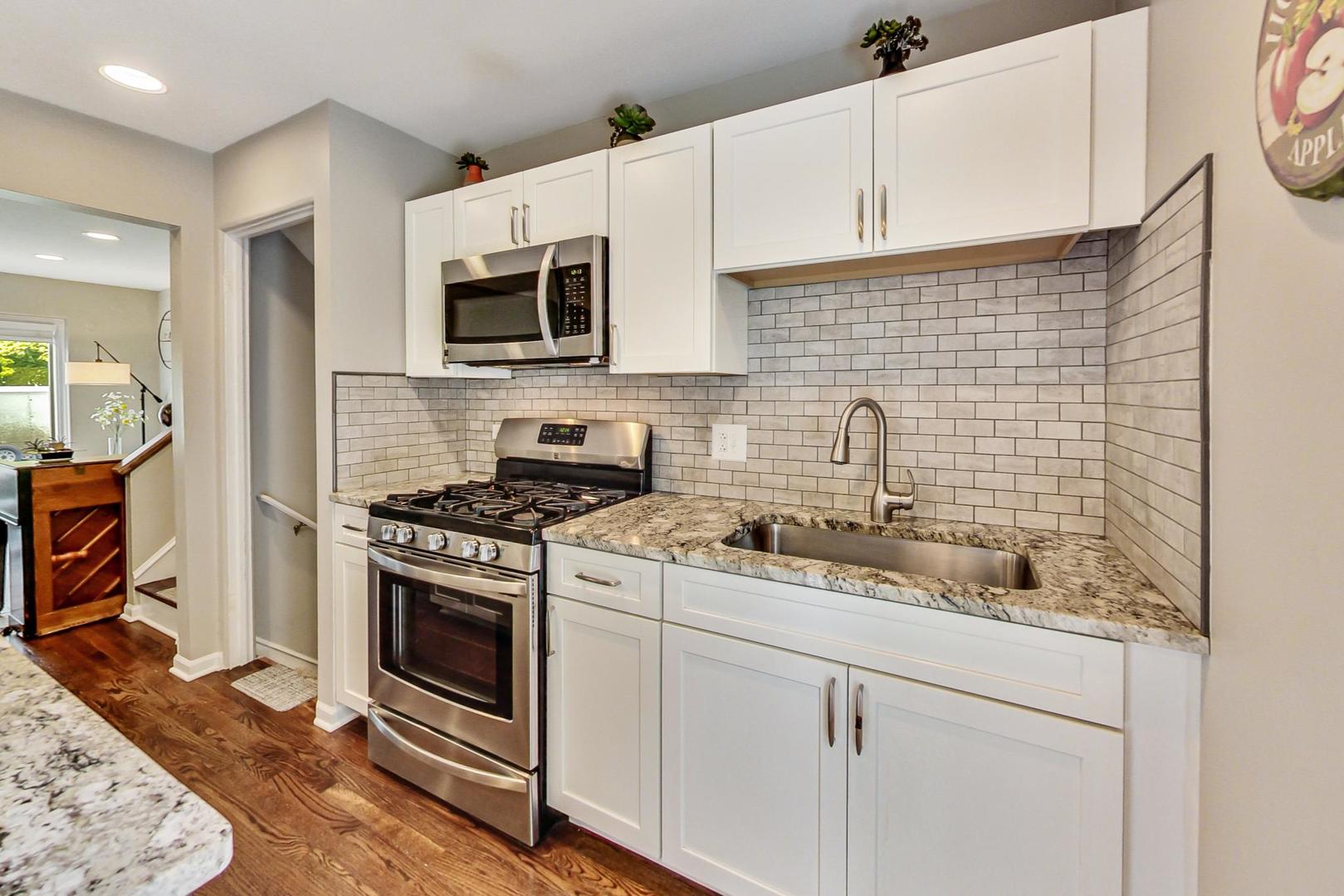 138 Northgate Road Riverside, IL 60546 - Photo 6 of 30 a kitchen with stainless steel appliances granite countertop white cabinets a stove top oven a sink and dishwasher