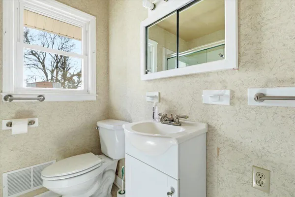 a bathroom with a toilet a sink and a mirror