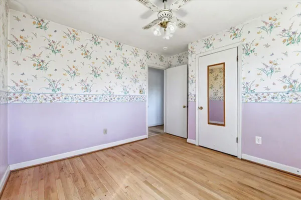 a view of a hallway with wooden floor and a chandelier
